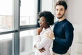 Romantic mixed race couple standing by the window thinking about their future. Royalty Free Stock Photo