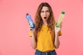 Photo of irritated caucasian woman holding plastic bottles Royalty Free Stock Photo