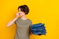 Photo of irritated displeased girl dressed green t-shirt disgusting dirty clothes aroma close nose isolated yellow color