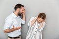 Photo of man in casual clothes screaming at pretty woman isolated over gray background