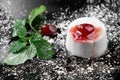 Photo of italian panna cotta dessert with strawberry sirup and mint leaf on the black wooden background. Royalty Free Stock Photo