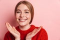 Photo of joyful beautiful woman in red sweater laughing at camera