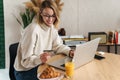 Photo of joyful blonde woman holding credit card and using laptop Royalty Free Stock Photo