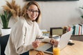 Photo of joyful blonde woman holding credit card and using laptop Royalty Free Stock Photo