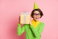 Photo of joyful cheerful excited young woman hold shake gift box receive birthday present isolated on pink color