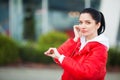 Photo of Joyful Fitness Woman 30s in Sportswear Touching Bluetooth Earpod and Holding Mobile Phone, While Resting in