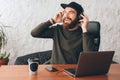 Joyful happy man with beard listening music and relaxing in pause at work