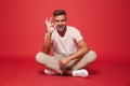 Photo of joyful man 30s in striped t-shirt smiling, while sittin