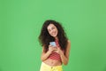 Photo of joyful woman smiling and using cell phone isolated over green background Royalty Free Stock Photo