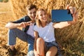 Photo of joyous couple man and woman taking selfie on smartphone