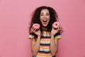 Photo of joyous woman 20s with curly hair having fun and holding