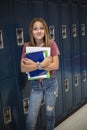 Junior High school Student standing by her locker in a school hallway