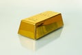 Photo of 1kg gold bar isolated on a blue background with reflection,