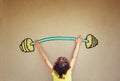 Photo of kid's back view lifting up barbell weights Royalty Free Stock Photo