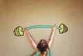 Photo of kid's back view lifting up barbell weights Royalty Free Stock Photo