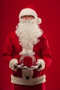 Photo of kind Santa Claus giving xmas present and looking at cam Royalty Free Stock Photo