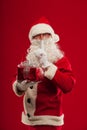 Photo of kind Santa Claus giving xmas present and looking at cam Royalty Free Stock Photo