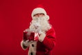 Photo of kind Santa Claus giving xmas present and looking at cam Royalty Free Stock Photo