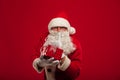 Photo of kind Santa Claus giving xmas present and looking at cam Royalty Free Stock Photo