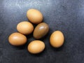 Photo kinder Easter chocolate egg with natural chicken eggs on a black table.
