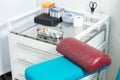 Photo of a laboratory with a patient's chair and a table with a medical tray with a syringe and test tubes for taking