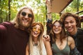 Photo of laughing hippie people men and women taking selfie in f