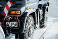 Photo from the left side. Jeep with snow chains parked indoors at the white tile on vehicle show Royalty Free Stock Photo