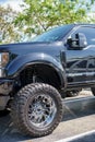 Photo of a lifted Ford F250 black with off road tires and chrome rims