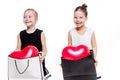 2 little girls with elegant dresses hold large bags with heart-shaped balloons inside Royalty Free Stock Photo