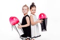 2 little girls with elegant dresses hold large bags with heart-shaped balloons inside Royalty Free Stock Photo