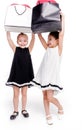 2 little girls with elegant dresses hold large bags with heart-shaped balloons inside Royalty Free Stock Photo