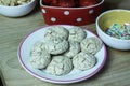 a little porcelain plate of a bunch of meringue biscuits with strawberries and hundreds and thousands in the background Royalty Free Stock Photo