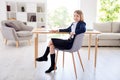 Photo of little pretty cheerful pupil girl good mood return school online way learning sit chair desk wear uniform