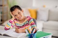 Photo of little young age school boy wear striped stylish casual pullover writing his dictation essay pencil open