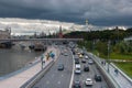 In the photo, a lot of cars - mainly passenger passenger taxis - rush along the three-lane road to the viewer and back