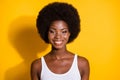 Photo of lovely black young girl look camera toothy smile wear white tank-top isolated yellow color background Royalty Free Stock Photo