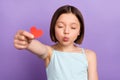 Photo of lovely brown hairdo small girl blow kiss give heart wear blue top isolated on violet color background