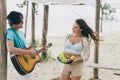 Photo of lovely cute couple spend their honeymoon at tropical island wife listening her husband playing guitar ballad