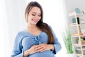 Photo of lovely cute dreamy mama touching her belly feeling baby enjoying beautiful period first pregnancy morning light