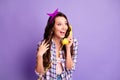 Photo of lovely excited girl hold wired phone listen look empty space wear plaid shirt vintage headband isolated purple Royalty Free Stock Photo