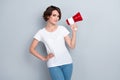 Photo of lovely good mood woman with short hairdo dressed white t-shirt hold megaphone hand on waist isolated on gray