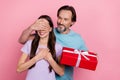 Photo of lovely husband give wife birthday present cover her eyes make surprise isolated on pink color background