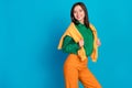 Photo of lovely lady stand empty dressed orange green cozy clothes ready walk outside good mood weather isolated on blue Royalty Free Stock Photo