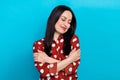 Photo of lovely satisfied woman with straight hairdo dressed dotted shirt embrace herself close eyes isolated on blue Royalty Free Stock Photo