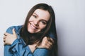 Photo of lovely smiling woman embraces herself