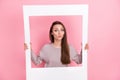 Photo of lovely sweet lady hand hold white paper picture dressed stylish pullover send kiss camera isolated on pink Royalty Free Stock Photo