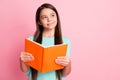 Photo of lovely sweet little ponderous latin lady long hairstyle arms hold orange book sly look up empty space