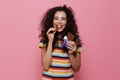 Photo of lovely woman 20s with curly hair eating chocolate bar,