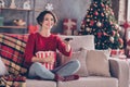 Photo of lovely young lady hold remote control embrace popcorn paper box sitting couch wear red sweater jeans socks