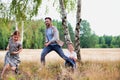 Loving father playing with his daughter in the woods whilst his wife watches and his happy